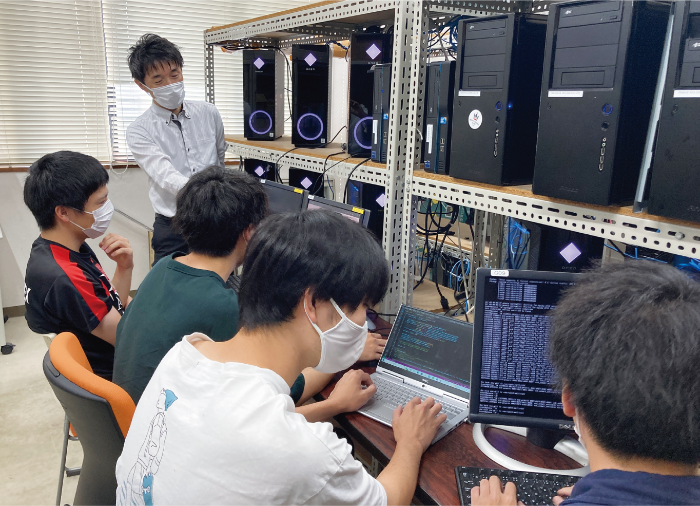 研究室で指導する小野教授