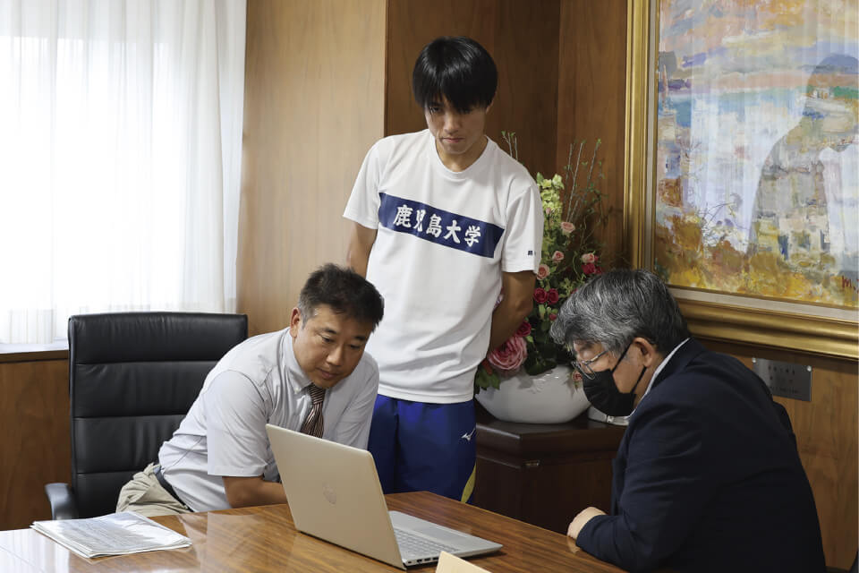 九州地区選考会での様子を動画で紹介する顧問の塗木准教授